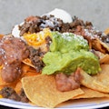 NACHOS SUPREME-Meat, Cheese, Beans, Guacamole, Sour Cream, and Cotija Cheese
