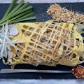 Pad Thai wrapped in egg nest 